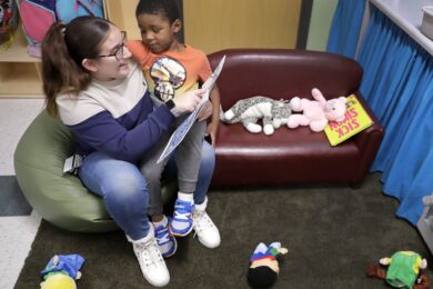 Teaching assistant Anna Muniz reads a book together during a Head Start preschool class in Wisconsin on Thursday, April 4, 2024.