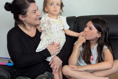 Brittany Neal with daughters Stormi, 3, and Madison, 11 at their home in North Canton. The family has taken on the mission of producing adaptive mobile devices for children with disabilities using a 3-D printer.