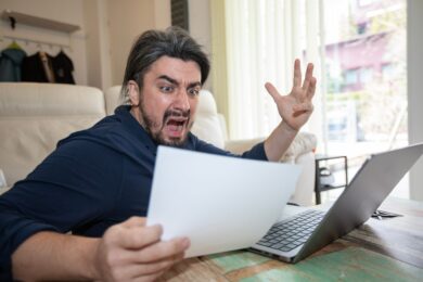 Handsome,Young,Man,Shocked,Over,High,Bill,In,Office